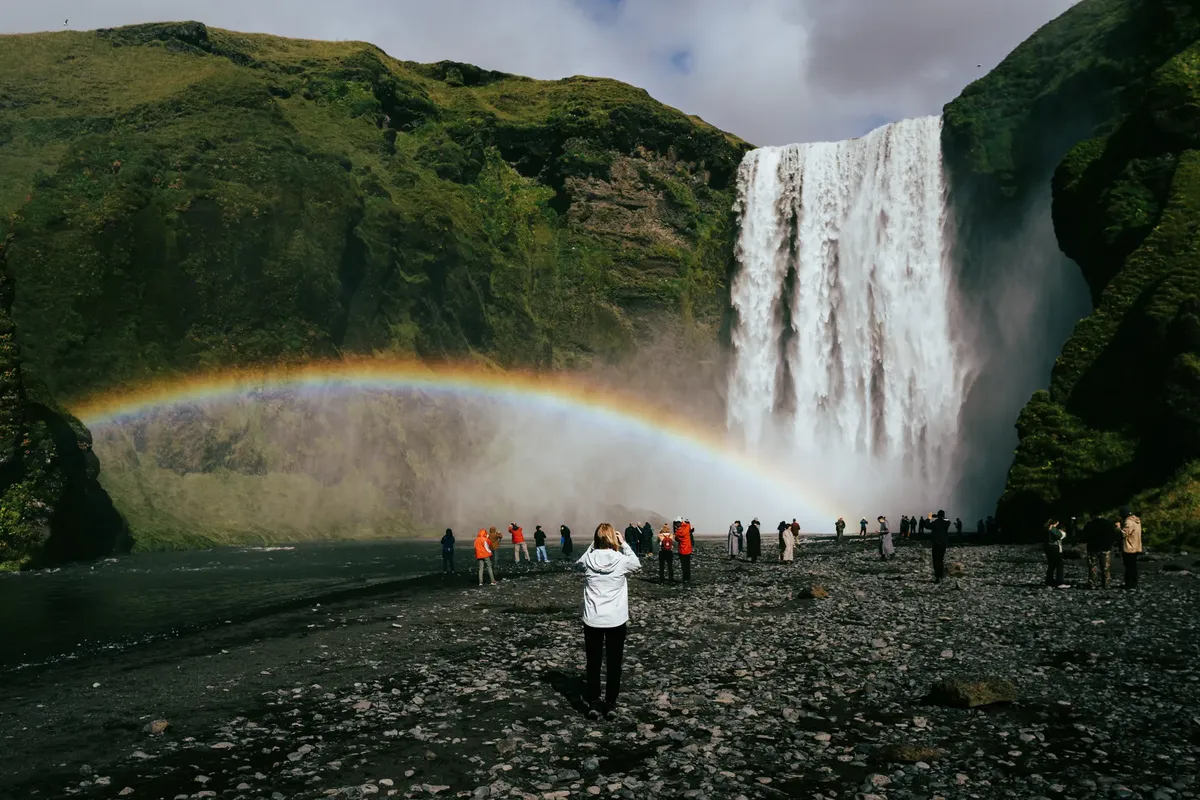 Stunning view of Skógafoss waterfall with a rainbow in Rangárþing eystra, Iceland.