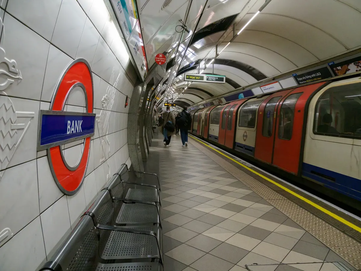 View of the Bank Station platform in the London Underground with a train and passengers.